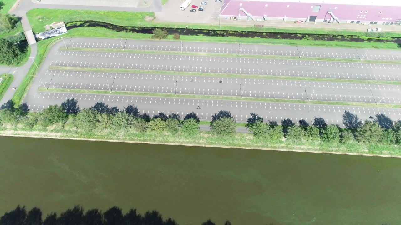 큰 주차장에서 운전하는 법을 배우는 모터사이클의 높은 공중 드론  ⁇