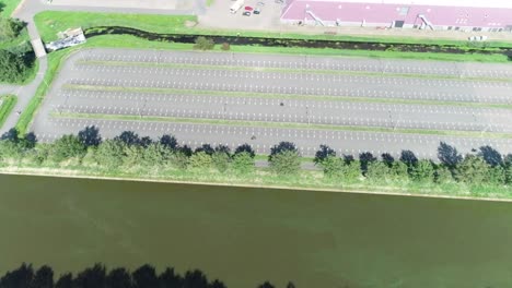 high aerial drone shot of motorcyclist learning how to drive in a big parking lot