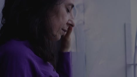 alone in adversity: stressed woman reflected on a window while dealing with challenges