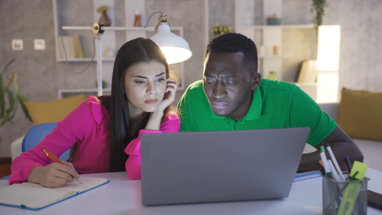 retrato de un joven y una mujer independientes, un joven africano y una mujer caucásica trabajando con una computadora portátil.