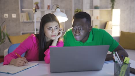 retrato de un joven y una mujer independientes, un joven africano y una mujer caucásica trabajando con una computadora portátil.