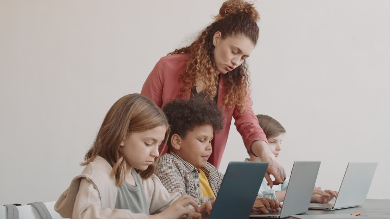 Teacher Helping Students on IT Lesson