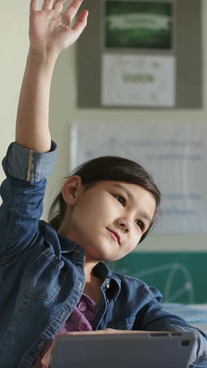 Video verticale: Studente in camicia di jeans che si ferma, alza la mano in classe per rispondere all'insegnante, tablet