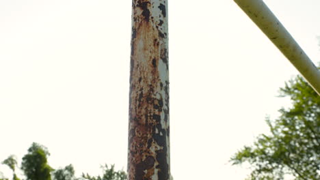 a lens flare dolly pan across a rusted old soccer goal post