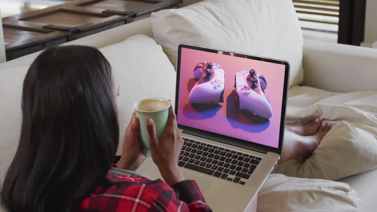 Biracial woman using laptop at home for online shopping, slow motion
