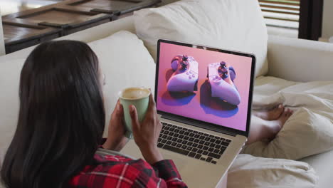 mujer biracial usando una computadora portátil en casa para comprar en línea, cámara lenta