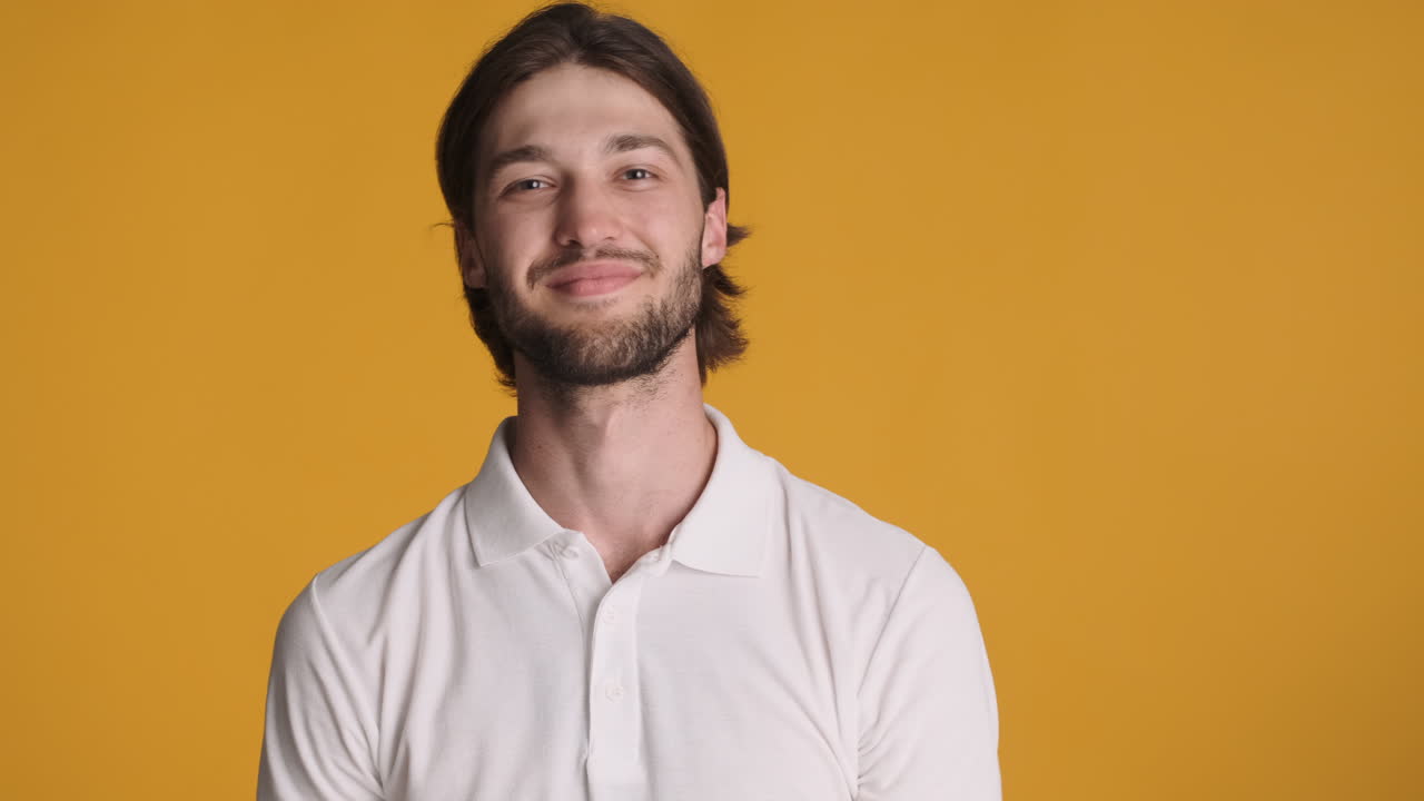 hombre caucásico haciendo un gesto ok en fondo amarillo.