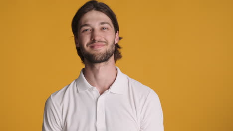 hombre caucásico haciendo un gesto ok en fondo amarillo.