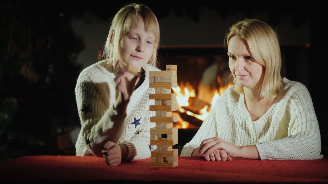 una mujer con un niño jugando un juego de mesa donde se necesita precisión
