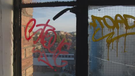 view of peckham in south london through graffiti covered windows in high rise