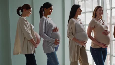 four pregnant women sharing a moment of joy