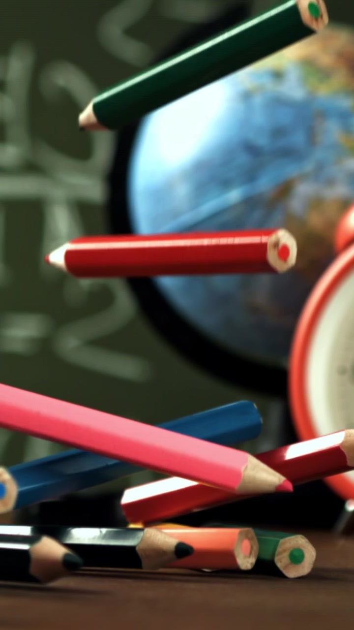 Colorful Pencils Falling onto a Desk with School Supplies