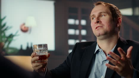 miembro de la sociedad de élite negociando con un socio sobre whisky mezclado