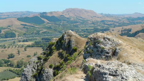 Die-Kamera-Wird-Wie-Auf-Einem-Kran-Hinter-Einem-Felsen-Angehoben,-Um-Einen-Wunderschönen-Hügel-Zu-Zeigen