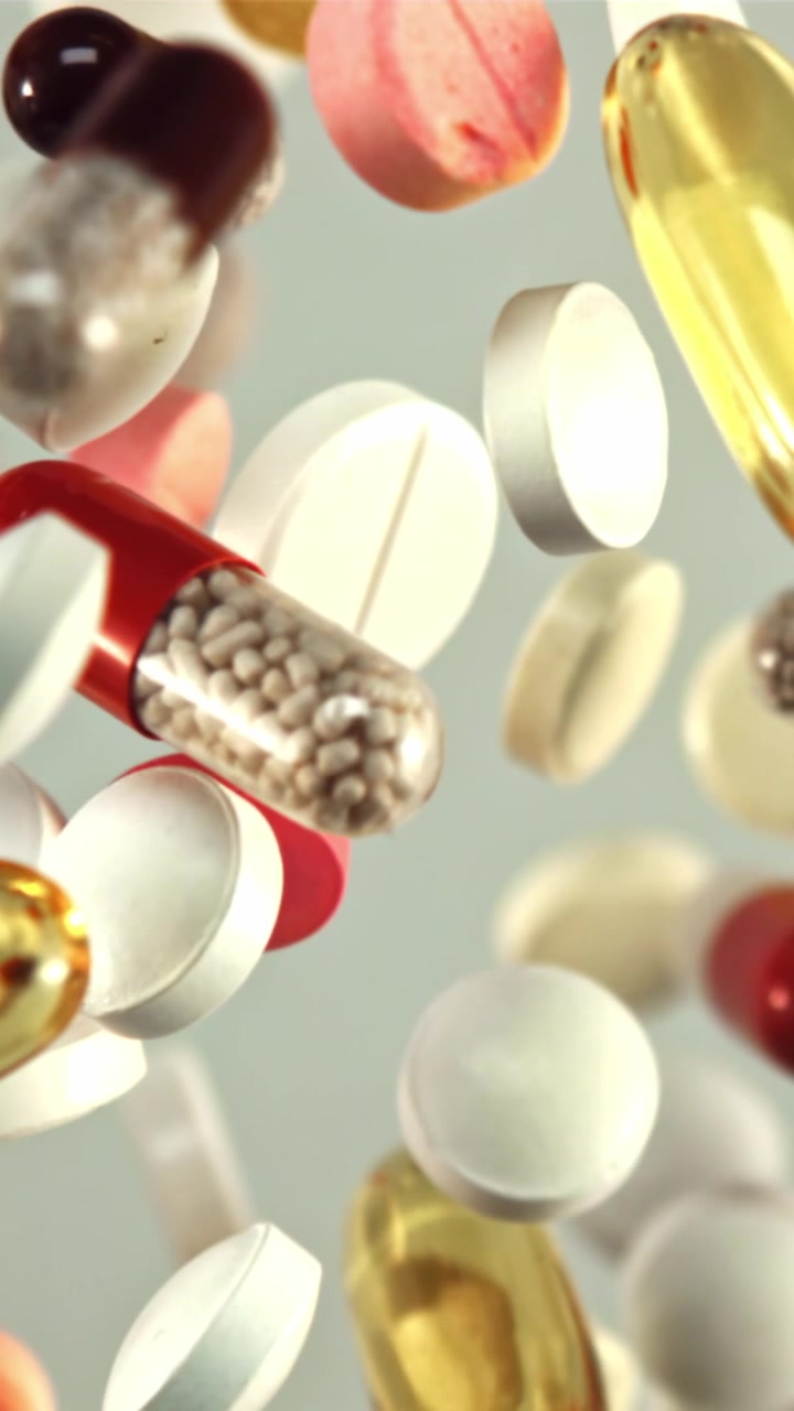 Colorful Pills and Capsules Falling in Slow Motion