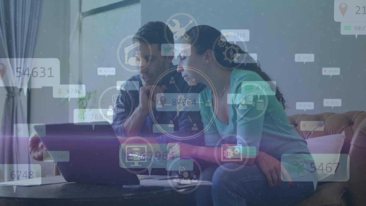 animación de iconos de las redes sociales sobre una pareja caucásica usando una computadora portátil juntos en casa.