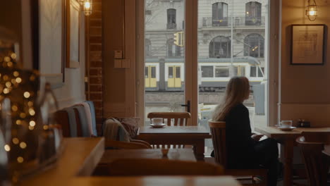 woman in a cafe watching a train go by
