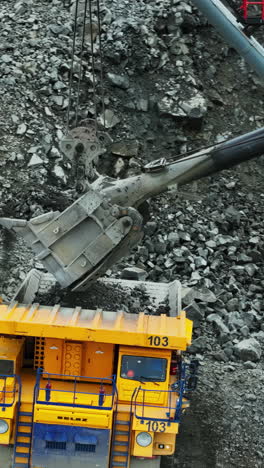 heavy machinery at work: excavator and dump truck in open-pit mining