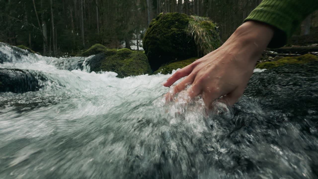Hand in a mountain stream