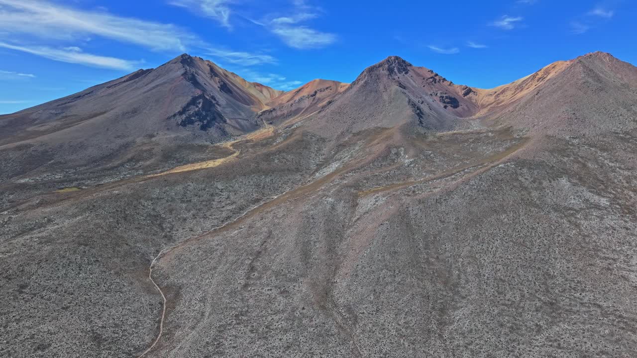 Una ripresa aerea da lontano mostra tutta la grandiosità del vulcano Picchu Picchu, rivelandone le dimensioni iconiche e il drammatico paesaggio vulcanico che si estende attraverso il panorama di Salinas