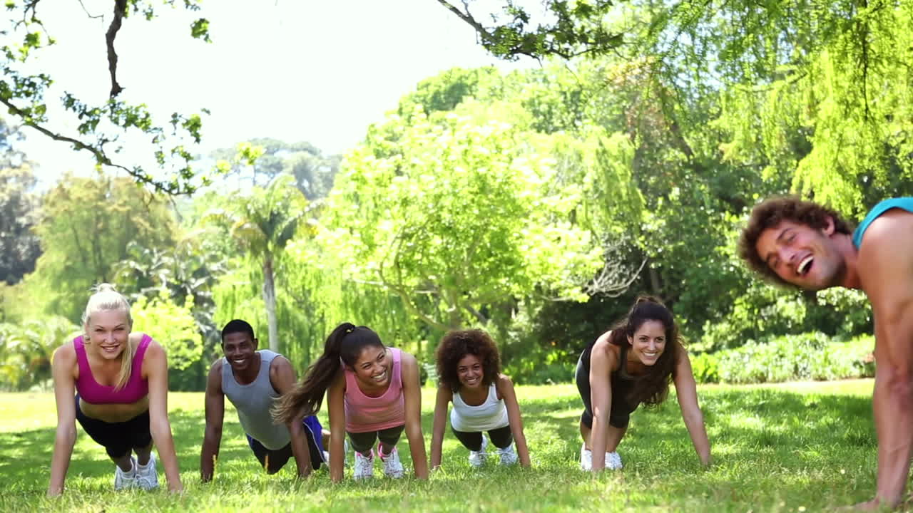 clase de fitness haciendo flexiones en el parque