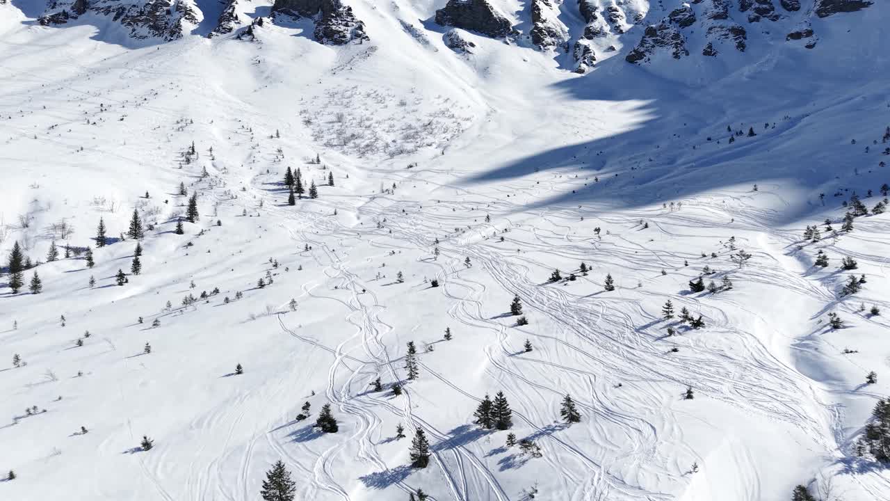 dji drone climbing swiss mountain valley on a sunny winter day.