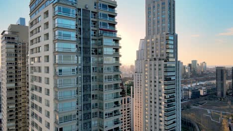 4k aerial drone footage of apartment buildings with fast pull out dolly of apartments during sunset