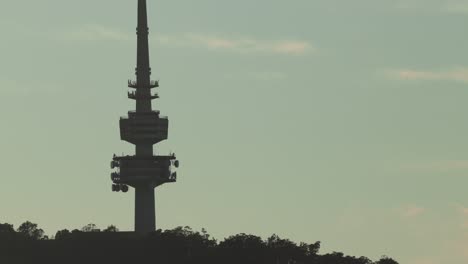 a detailed close view of the silhouetted canberra tower set against a soft blue sky at first light