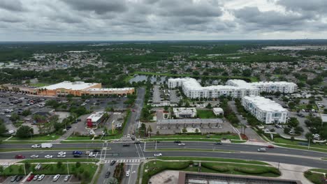 shopping center and luxury residential apartments with highway and driving cars in orlando, florida. aerial lateral wide shot.