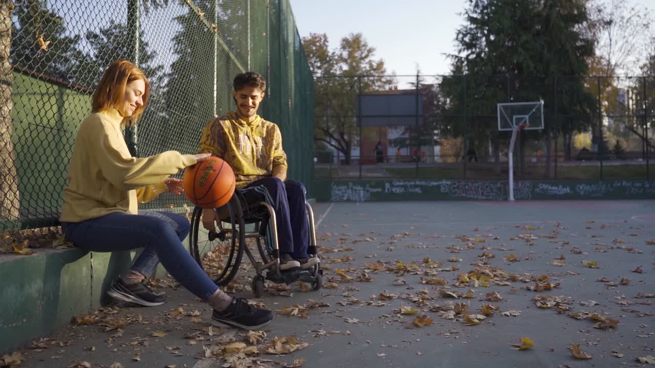 en cámara lenta, un joven discapacitado y su novia están charlando en la cancha de baloncesto.