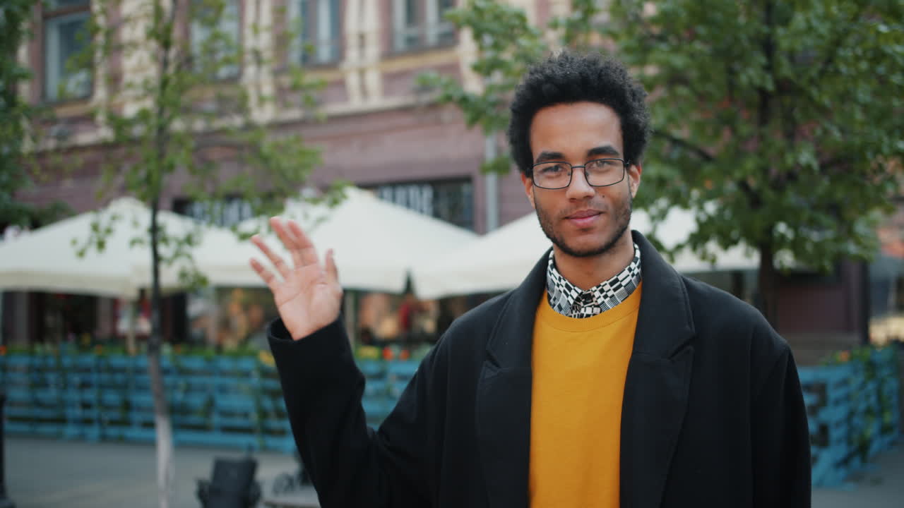 Man Waving Hello Outside Cafe