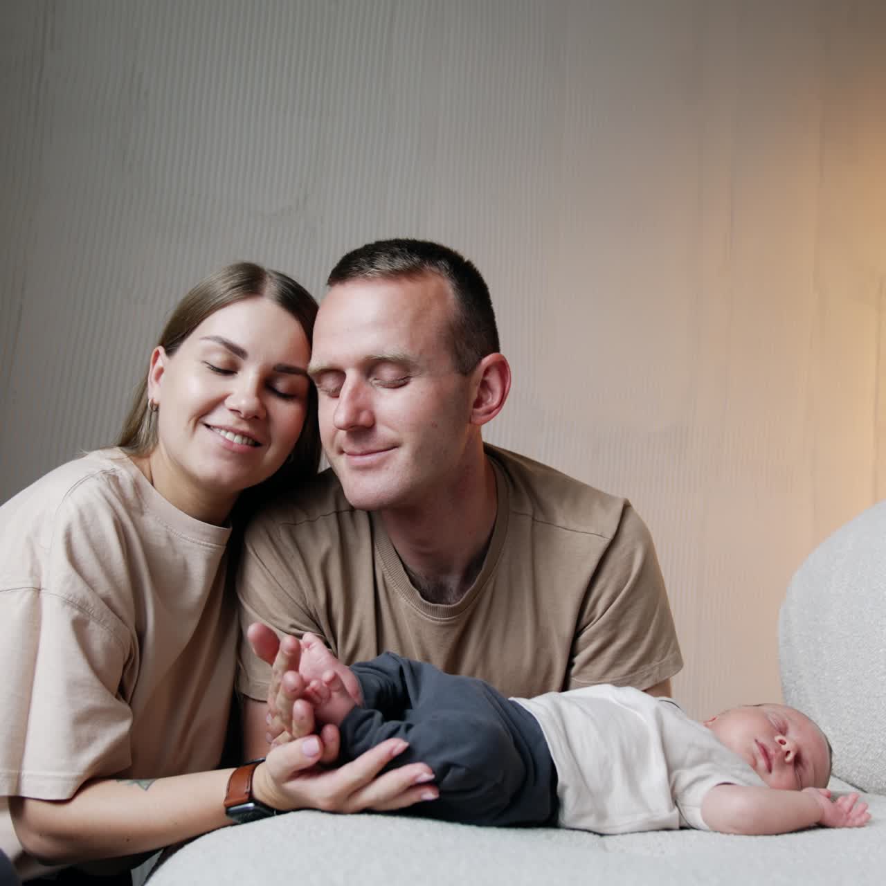 Casal caucasiano feliz com seu bebê. Pais carinhosos sentam-se perto de seu bebê, segurando os pequenos pés