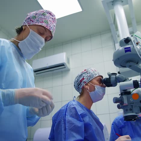 surgeon looking into the microscope