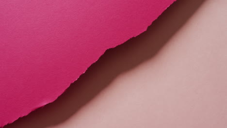 video de primer plano de pedazos rasgados de papel de fondo rosa oscuro y claro.