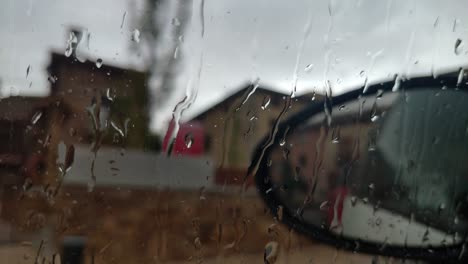blurred raindrops on window, cloudy weather with a building in the background