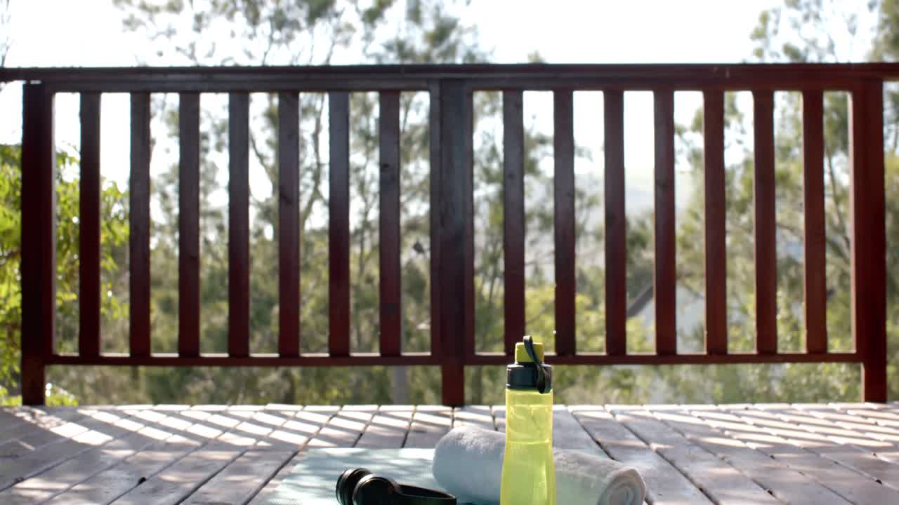 토월, 물 한 병, 헤드폰 및 스마트폰 로그 캐빈에서 요가 매트에, 슬로우 모션