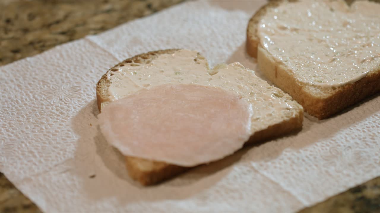 hombre preparando un sencillo sándwich de pechuga de pavo con crema