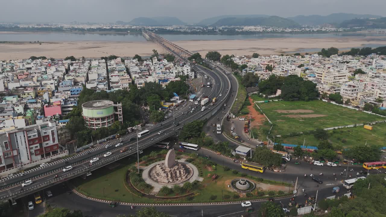 An aerial video of Vijayawada, a thriving city highlights its dynamic urban landscape, including the picturesque Krishna River. The iconic Dharma Chakra Circle is a prominent landmark in the city