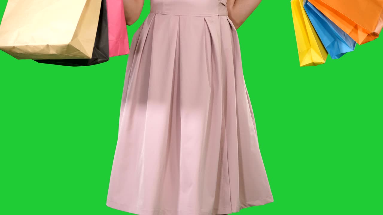 Woman holding shopping bags in her hands and making a turn on a Green Screen, Chroma Key