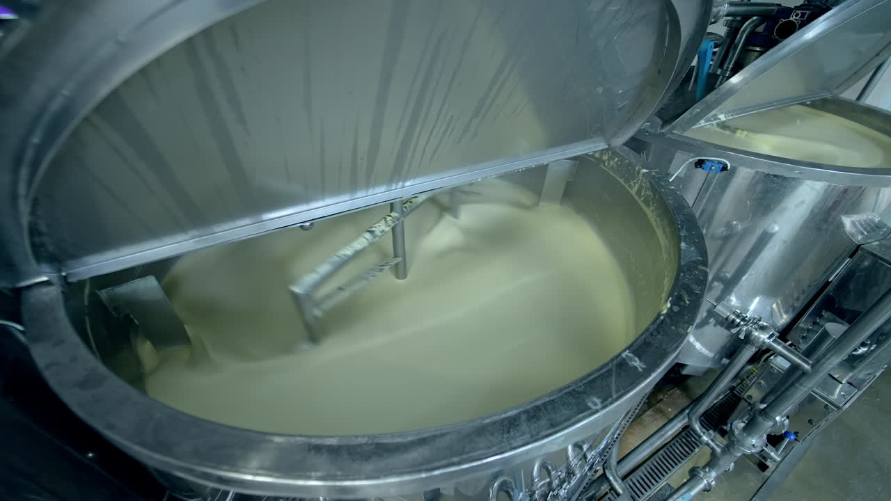 Industrial equipment for making butter. Modern container mixing butter at milk factory. Creamy dairy product in a tank