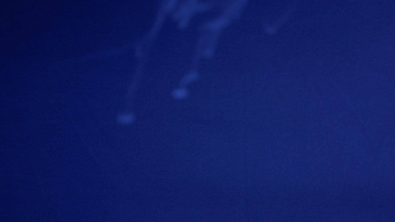 A mesmerizing cloud of blue smoke drifts dramatically across a dark, moody sky. The atmospheric lighting enhances the mysterious and ethereal quality of this captivating scene