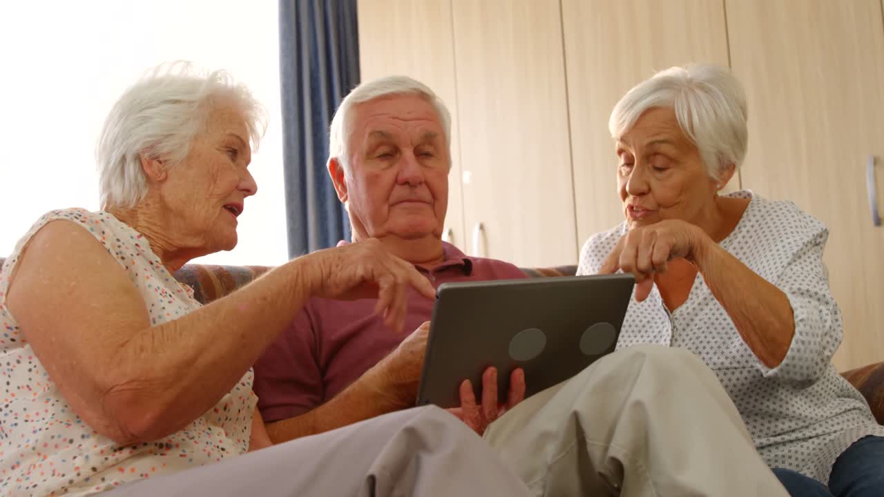 Amici anziani che conversano con un tablet.