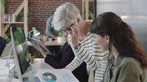 mujer de negocios madura líder formación joven pasante mostrando datos de investigación profesionales corporativos colaborando utilizando tecnología informática en el espacio de trabajo de oficina moderno