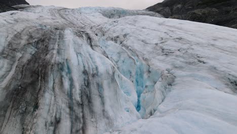 Vista-Aérea-De-Los-Detalles-De-Un-Glaciar-Descongelado-Con-Hielo-Tiznado-Y-Agua-Glacial---Concepto-De-Cambio-Climático