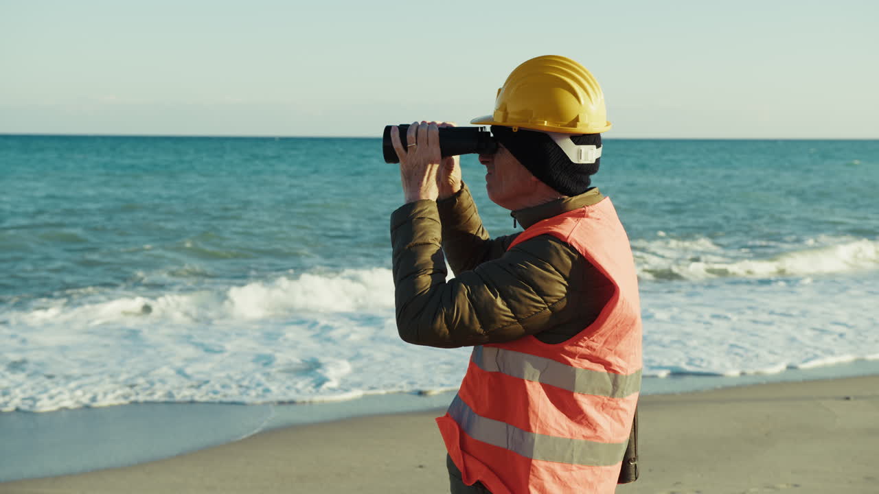 Construction Worker Using Binoculars to Observe the Ocean