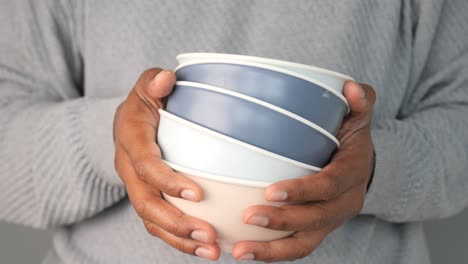 person holding stacked bowls