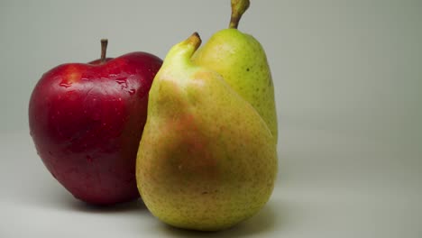 fresh red apple and two beautiful fresh pears rotating clockwise with pure white background - close up