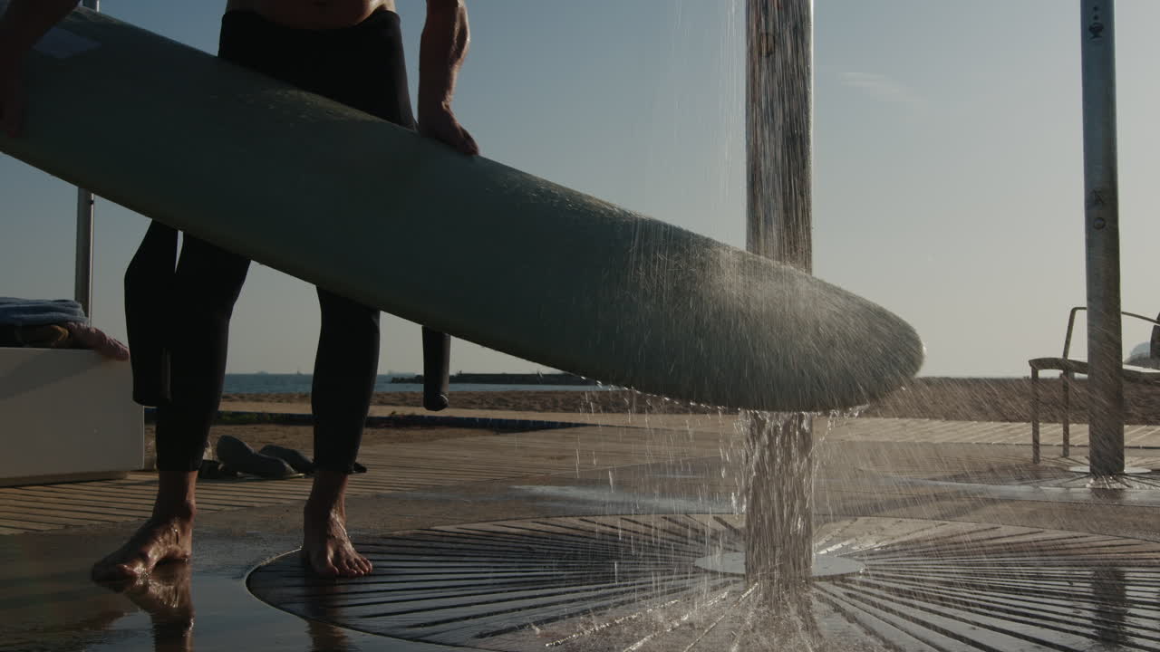 Surfer man walking to the beach at sunset preparing for surfing training and search for waves in Barcelona, spain, water, ocean exercise in sea with board, athletic male holiday or travel in vacation