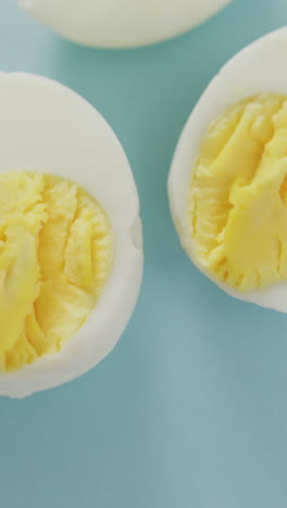 video of overhead view of three egg halves on blue background