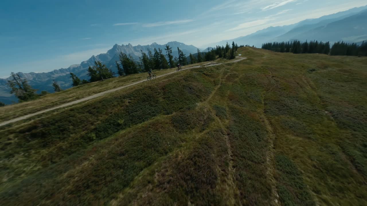 vista distante de dos ciclistas montados en la cima de la montaña